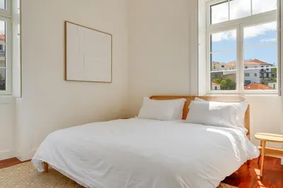 a white bed in a room with two windows at Luxury Quinta Rosa by Holiday Rental Madeira in Funchal