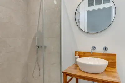 a bathroom with a sink and a shower with a mirror at Luxury Quinta Rosa by Holiday Rental Madeira in Funchal