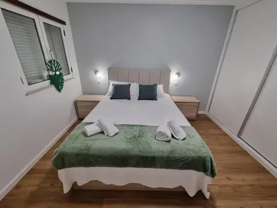 a bedroom with a large bed with a green blanket at Julianas Place by Susys Holidays in Funchal