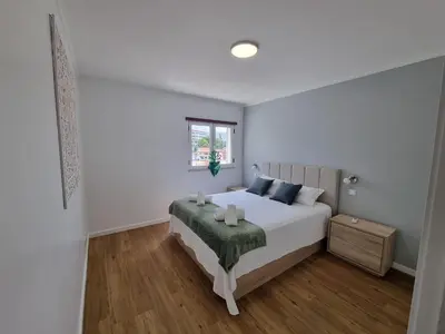 a white bedroom with a white bed and a window at Julianas Place by Susys Holidays in Funchal