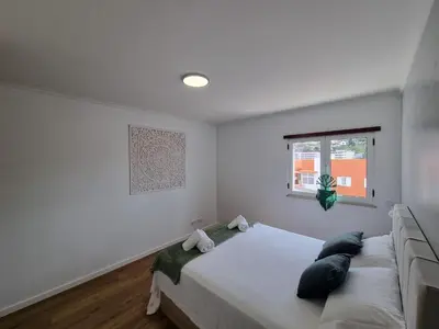 a white bedroom with a bed and a window at Julianas Place by Susys Holidays in Funchal