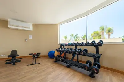 a room with a gym with a bunch of weights at Beach Condominium 28 by Destination Algarve in Atalaia