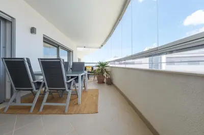 a balcony with a table and chairs in a building at Beach Condominium 28 by Destination Algarve in Atalaia