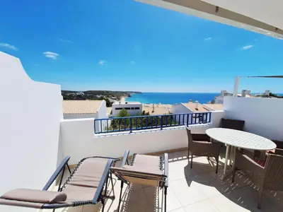 a balcony with a table and chairs and a view of the ocean at Casa Calma in Salema