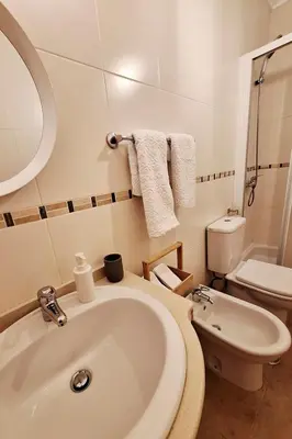 a white bathroom with a sink and a toilet at Casa Calma in Salema