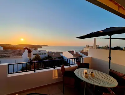a balcony with a table and a view of the ocean at Casa Calma in Salema