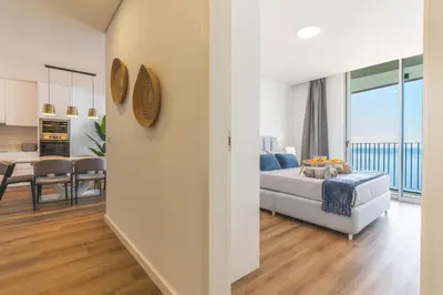 a bedroom with a bed and a living room and a kitchen at Atlantic View Apartment by Atlantic Holiday in Câmara de Lobos