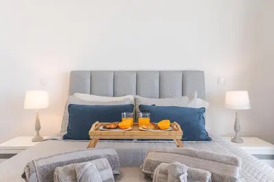 a bed with a tray of oranges and two glasses of juice at Atlantic View Apartment by Atlantic Holiday in Câmara de Lobos