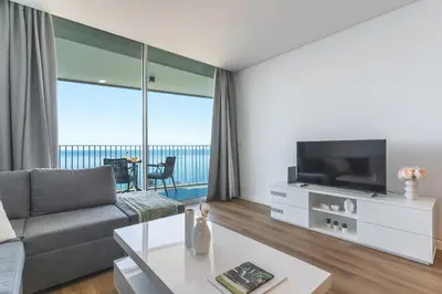 a living room with a couch and a tv at Atlantic View Apartment by Atlantic Holiday in Câmara de Lobos