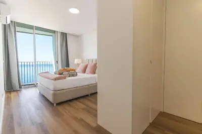 a bedroom with a bed and a large window at Atlantic View Apartment by Atlantic Holiday in Câmara de Lobos