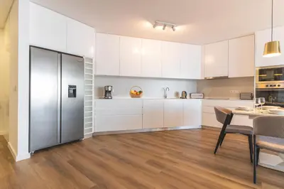 a kitchen with white cabinets and a table with chairs at Atlantic View Apartment by Atlantic Holiday in Câmara de Lobos