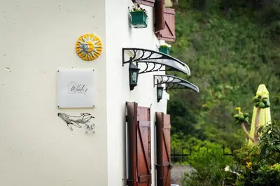 a building with a clock on the side of it at Whale's Lodge in Porto Moniz
