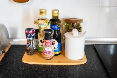 a wooden cutting board with bottles of condiments on a counter at Whale's Lodge in Porto Moniz