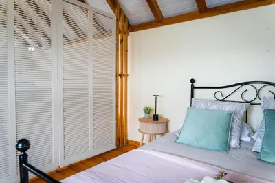 a bedroom with a large bed with blue pillows at Whale's Lodge in Porto Moniz