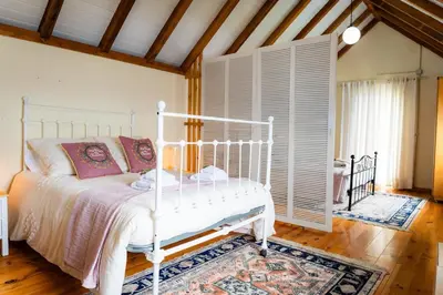 a bedroom with a white bed and a window at Whale's Lodge in Porto Moniz