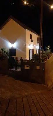 a house with lights on the side of it at night at Whale's Lodge in Porto Moniz