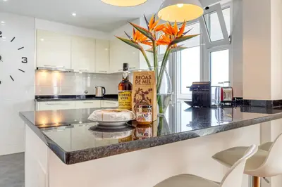 a kitchen with a counter with a vase of flowers at Baia Cliff View, a Home in Madeira in Funchal