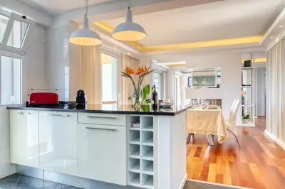 a kitchen with white cabinets and a black counter top at Baia Cliff View, a Home in Madeira in Funchal