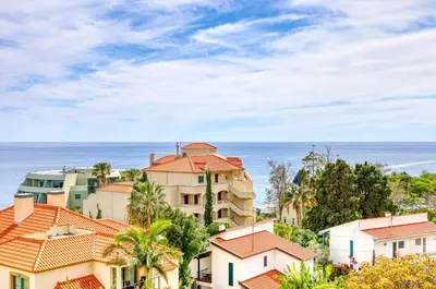 a group of houses with the ocean in the background at Baia Cliff View, a Home in Madeira in Funchal