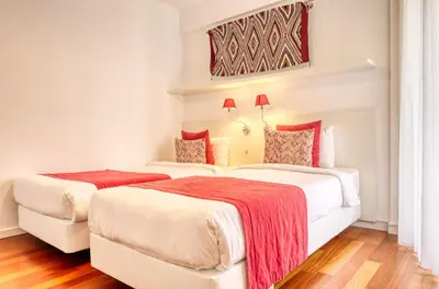 two beds in a hotel room with red blankets at Baia Cliff View, a Home in Madeira in Funchal