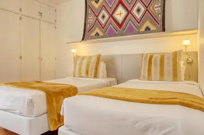 two beds in a room with a painting on the wall at Baia Cliff View, a Home in Madeira in Funchal