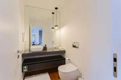a bathroom with a sink and a toilet and a mirror at Horizon Funchal in Funchal
