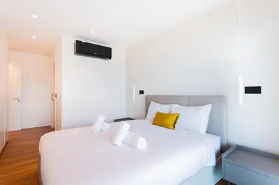 a bedroom with a large white bed with yellow pillows at Horizon Funchal in Funchal