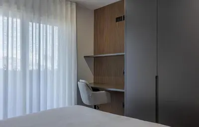 a bedroom with a bed and a chair and a book shelf at Horizon Funchal in Funchal