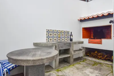 a room with a table and a fireplace at A Casa da Graça Reis by Horizon View Madeira in São Vicente