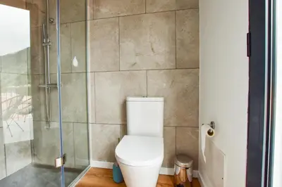 a bathroom with a toilet and a glass shower at A Casa da Graça Reis by Horizon View Madeira in São Vicente