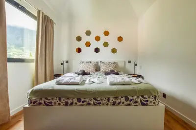 a bedroom with a bed with shoes on it at A Casa da Graça Reis by Horizon View Madeira in São Vicente