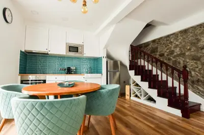 a kitchen with a wooden table and green chairs at A Casa da Graça Reis by Horizon View Madeira in São Vicente