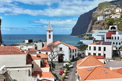 a view of a town with a church and the ocean at Serena Bay in Câmara de Lobos