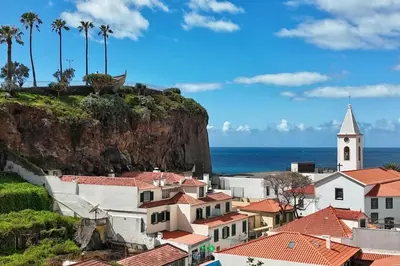 a view of a town with a church and the ocean at Serena Bay in Câmara de Lobos