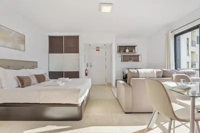 a bedroom with a bed and a couch and a table at Forum Garden View 5A by Homie in Funchal