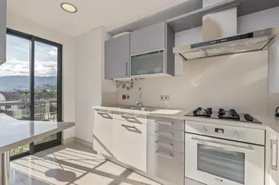 a kitchen with white appliances and a large window at Forum Garden View 5A by Homie in Funchal