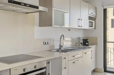 a kitchen with white cabinets and a sink at Forum Ocean View 5C by Homie in Funchal