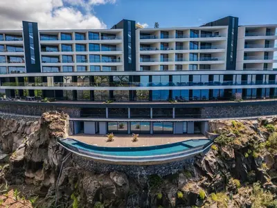 an office building with a boat in front of it at Atlantic Gem by Homie in Câmara de Lobos