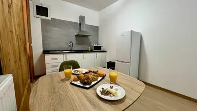 a kitchen with a table with a plate of food and orange juice at ZainAli Guest House in Funchal