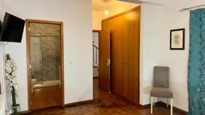 a hallway with a door and a chair in a room at ZainAli Guest House in Funchal