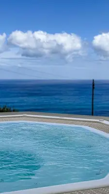 a swimming pool with the ocean in the background at Refúgio do Norte in Porto Moniz