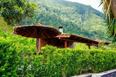 a small building with a umbrella in a field at Refúgio do Norte in Porto Moniz