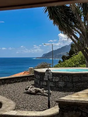 a swimming pool with the ocean in the background at Refúgio do Norte in Porto Moniz