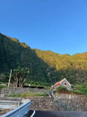 a house on the side of a mountain with a road at Refúgio do Norte in Porto Moniz