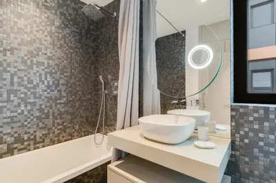 a bathroom with a white sink and a shower at Sky-High Elegance Top-Floor Views of City, Ocean & Sunrise in Funchal