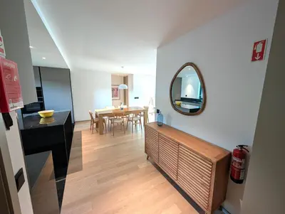 a living room with a table and a mirror at Sky-High Elegance Top-Floor Views of City, Ocean & Sunrise in Funchal