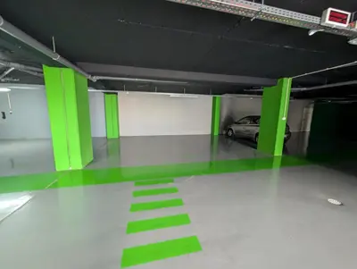 a parking garage with green doors and a car at Sky-High Elegance Top-Floor Views of City, Ocean & Sunrise in Funchal