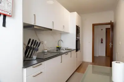 a kitchen with white cabinets and a sink at Garajau Sea View in Caniço