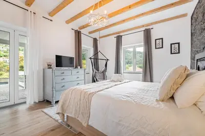 a bedroom with a bed and a tv and windows at Villa Pomar, By OP in Senhora do Rosário