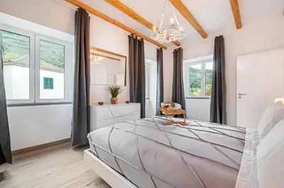 a bedroom with a large bed and windows at Villa Pomar, By OP in Senhora do Rosário